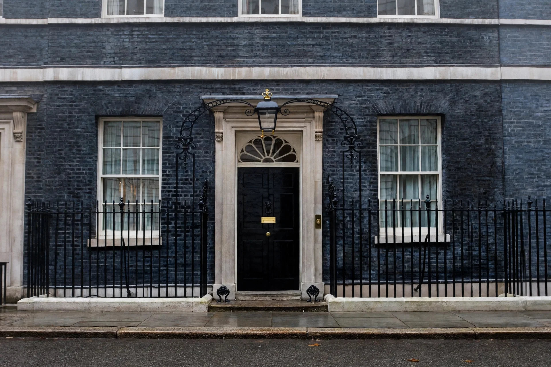 Fachada de Downing Street en Londres en una mañana gris, con la puerta negra oficial tras la verja de hierro