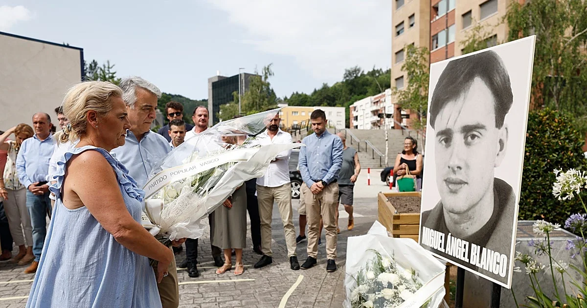 Acto de víctimas del terrorismo en España, con asistentes y pancartas en un espacio público