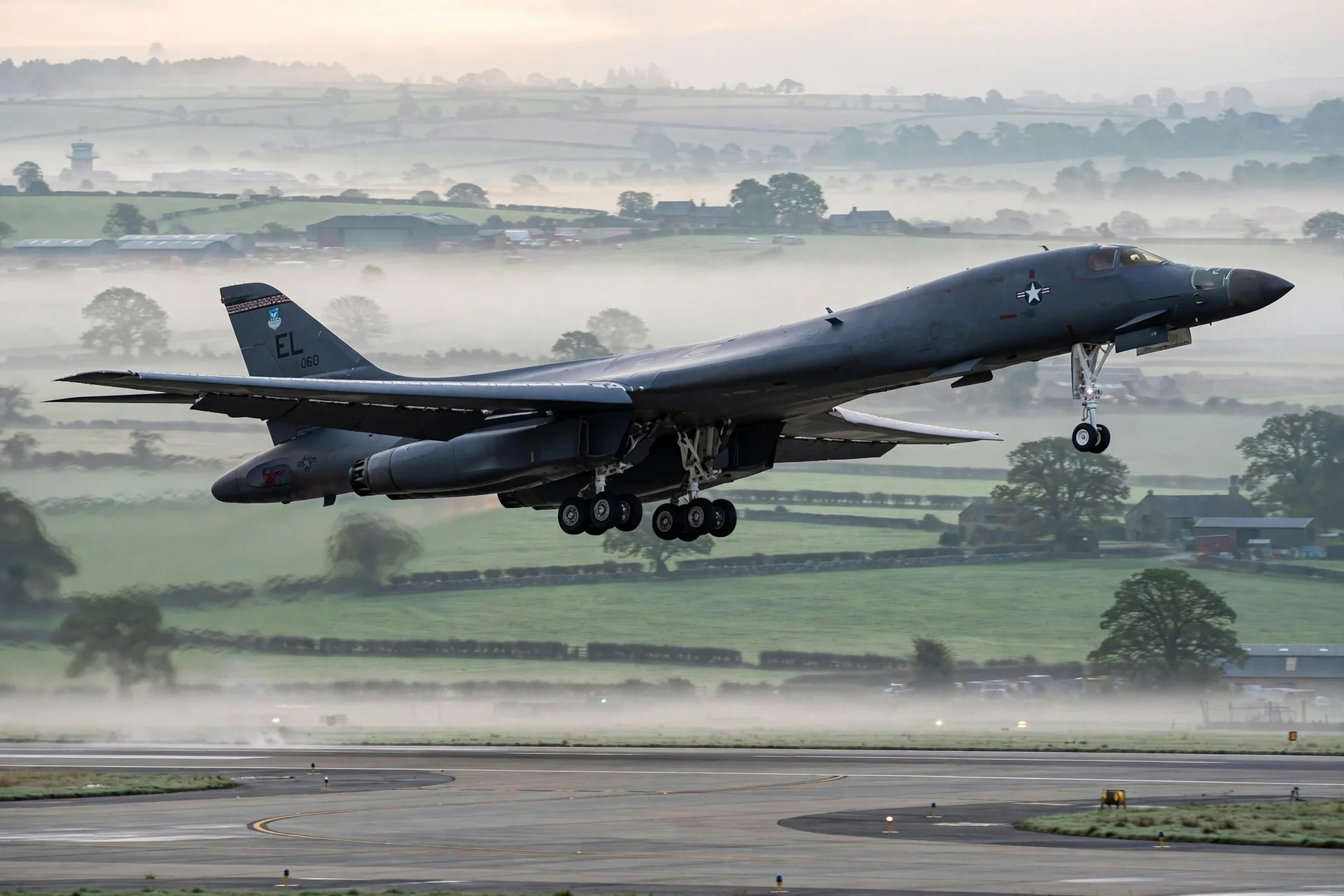 Bombardero estratégico B-1 de la Fuerza Aérea de EE. UU. despegando de una base aérea en la campiña inglesa al amanecer, entre niebla