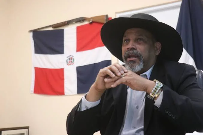 El alcalde de Dajabón, Santiago Riverón, durante unas declaraciones, con la bandera de República Dominicana al fondo