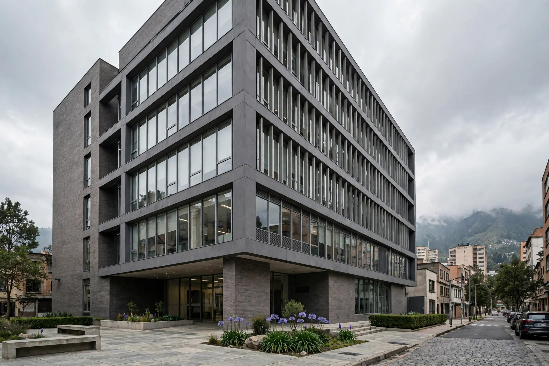 Edificio institucional moderno de fachada gris y ventanales en una esquina de Bogotá, bajo un cielo nublado y en ambiente sobrio