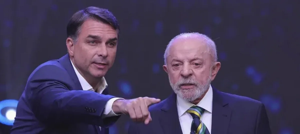 Flávio Bolsonaro señala con el dedo mientras habla junto a Luiz Inácio Lula da Silva durante el primer debate presidencial televisado en Brasil