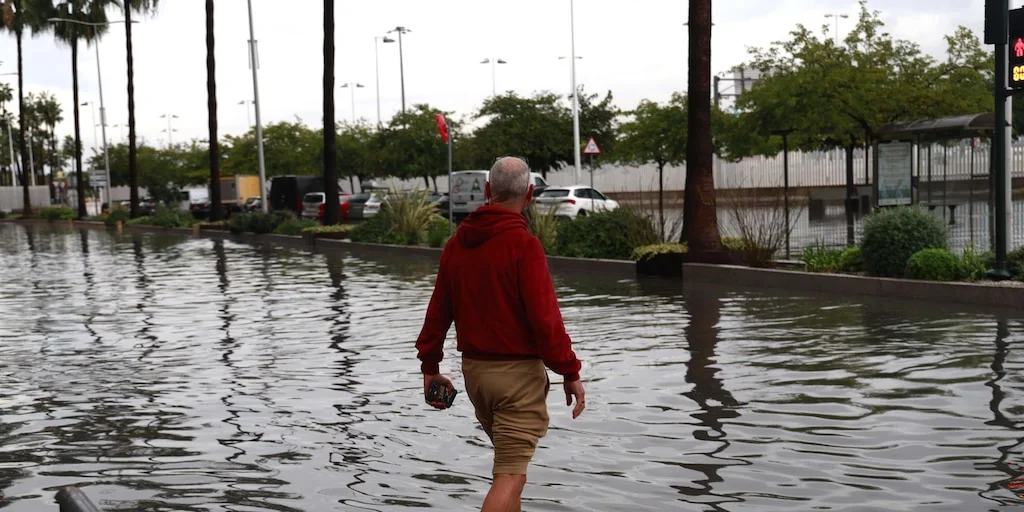Un hombre camina con el agua hasta las rodillas por una calle inundada durante la dana Adam en la Comunitat Valenciana